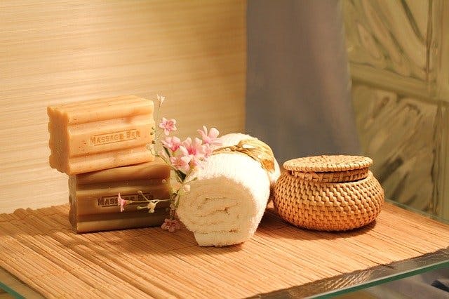 Seifenstücke und Handtuchrolle auf Bambusmatte.