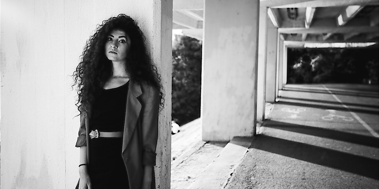 ABOUT YOU Gutschein Frau in modichem Outfit in einer Tiefgarage