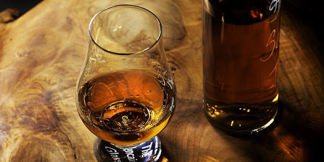 Whisky Glas und Flasche auf einem Holztisch