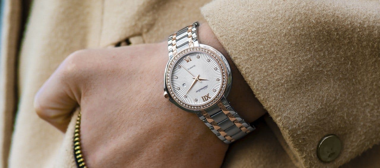 Nahaufnahme von einer angelegten silbernen Uhr mit goldenen Details