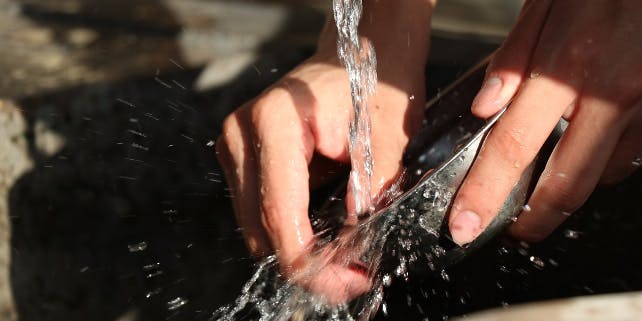 Abwasch einer Pfanne unter laufendem Wasser