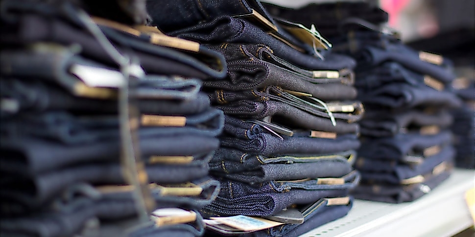 ntv-Jeans-Trends-Regal Viele dunkle Jeanshosen gestapelt in einem Regal