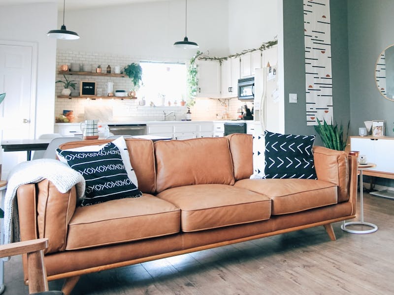 Hellbraunes Leder-Sofa in großem Wohnzimmer mit offener Küche