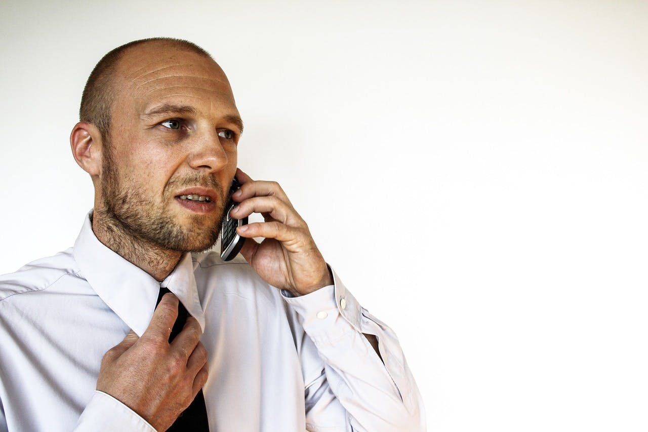 Erfolgreicher Geschäftsmann führt wichtiges Gespräch am Handy.