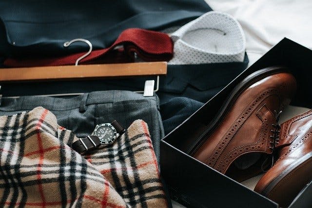 Lederschuhe, Armbanduhr und verschiedene Kleidungsstücke.