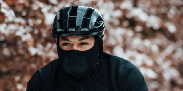 Mann auf dem Rad mit Helm und Gesichtsschutz