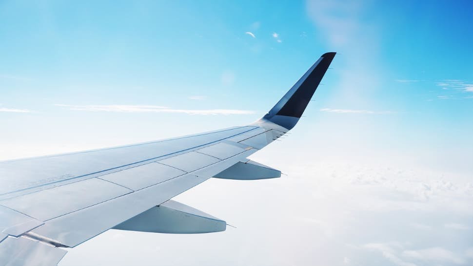 Blick aus dem Flugzeug zu den Tragflächen und dem Himmel