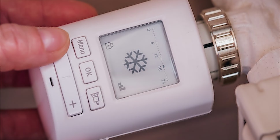 Person stellt sein programmierbares Thermostat ein