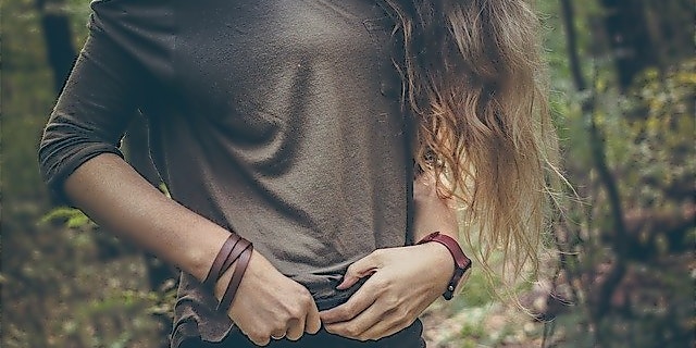Frau mit Bluse und Lederarmband vor Wald
