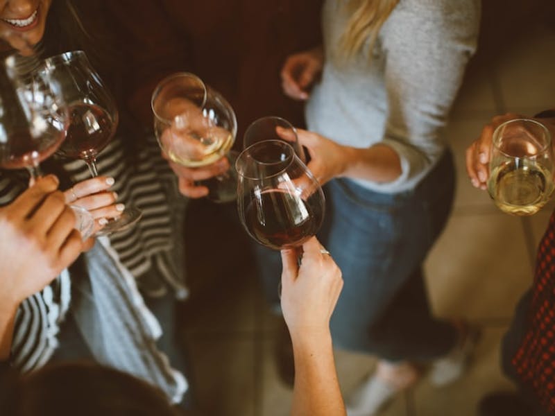 Junge Frauen trinken Weiß- und Rotwein auf der Party