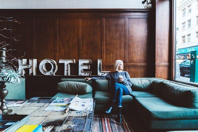 Frau sitzt in Hotel Lobby