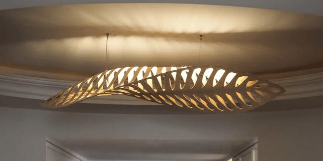Nachhaltige Lampe aus Holz in Blattform hängt an der Decke