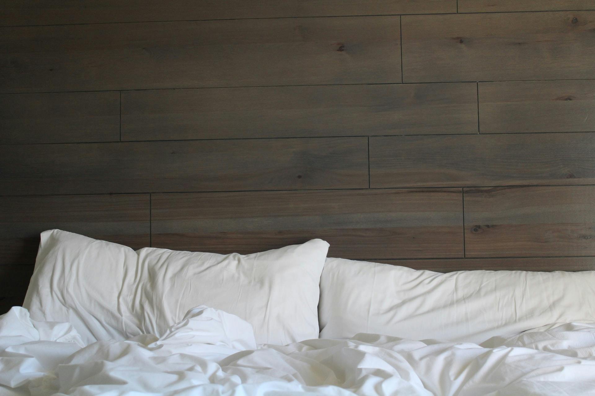 Kissen und Bettdecke auf Bett vor getäfelter Wand