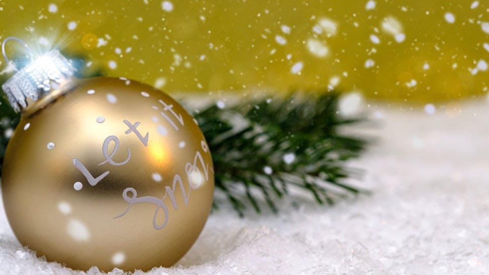 Goldene Weihnachtskugel mit dem Schriftzug "Let it snow"