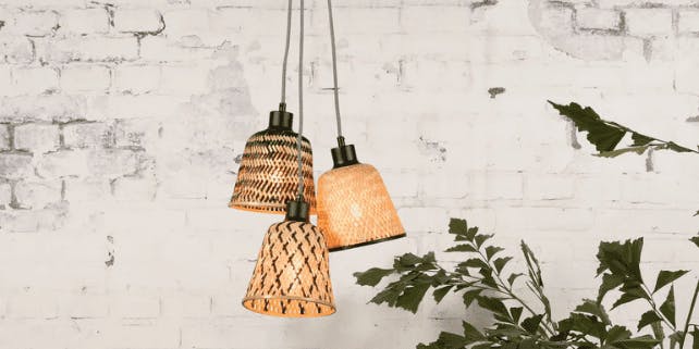 Nachhaltige Lampen aus Bambus hängen vor einer weißen Wand