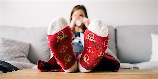 NTV_Heizkosten_Kleidung Frau mit dicken Socken und Tee auf der Couch