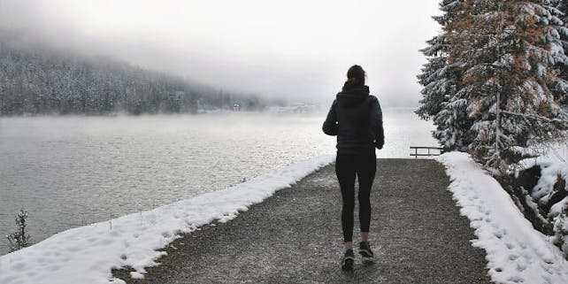 Laufen_im_Winter_Header Frau joggt am See, es liegt Schnee